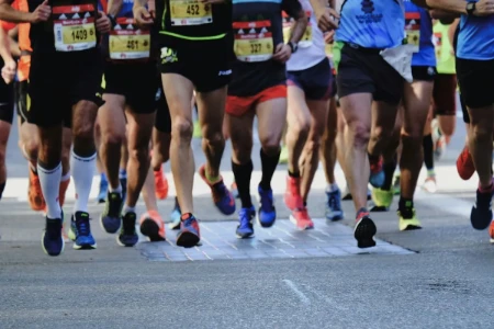 Grupo de corredores participando da Maratona do Rio de Janeiro, com foco nos pés em movimento durante a largada.