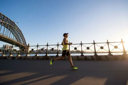 Atleta correndo ao pôr do sol durante treino para triatlo Ironman Brasil