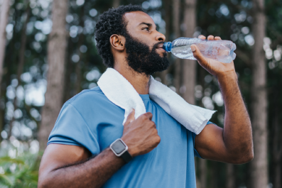 Homem bebendo água após praticar esportes em parque