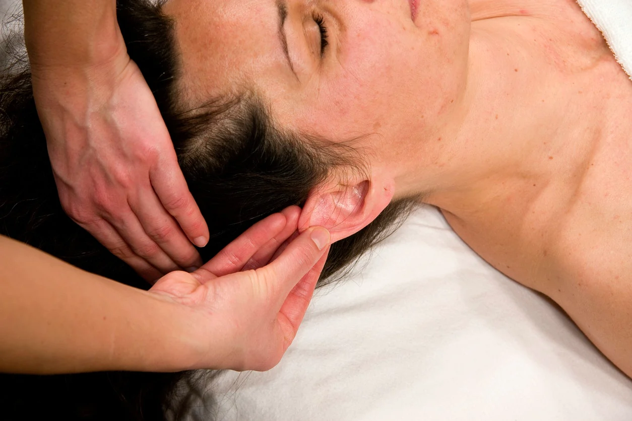 Mulher recebendo tratamento de acupunctura em seu rosto