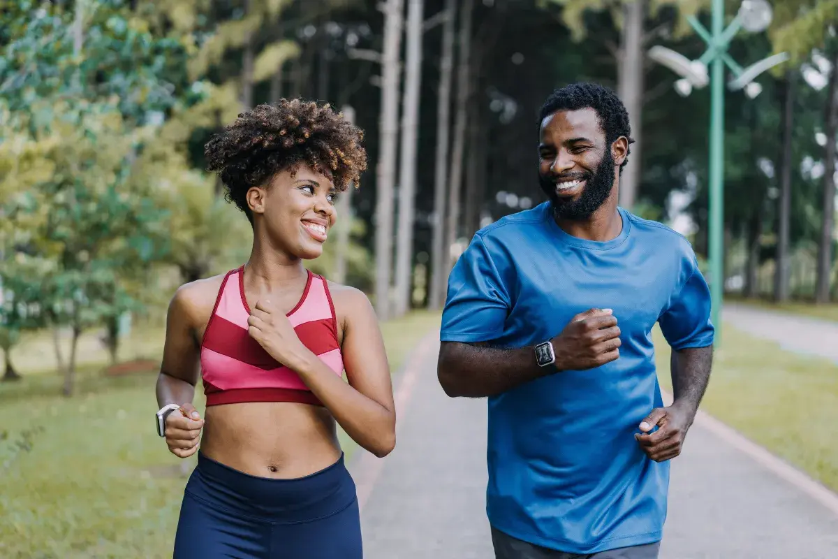 Mulher e homem correndo felizes no parque