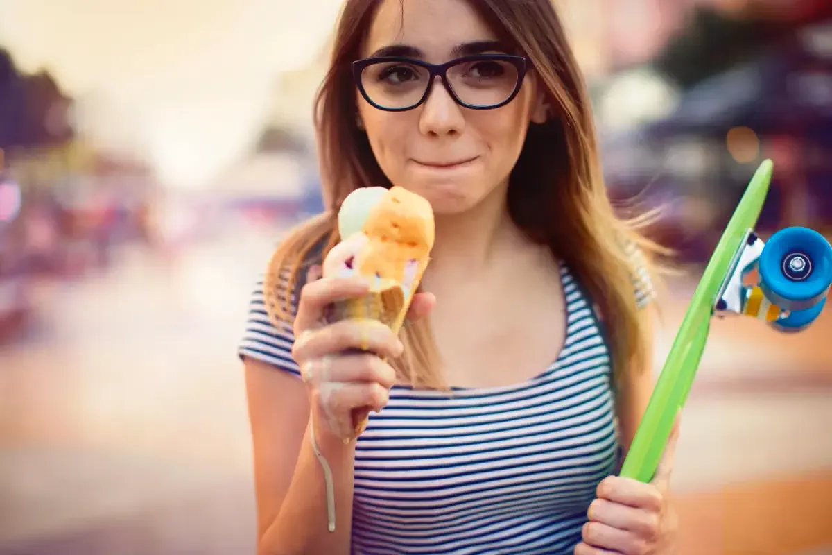 Mulher tomando sorvete com fisionomia de leve incomodo